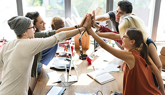 team of employees join for a group high-five