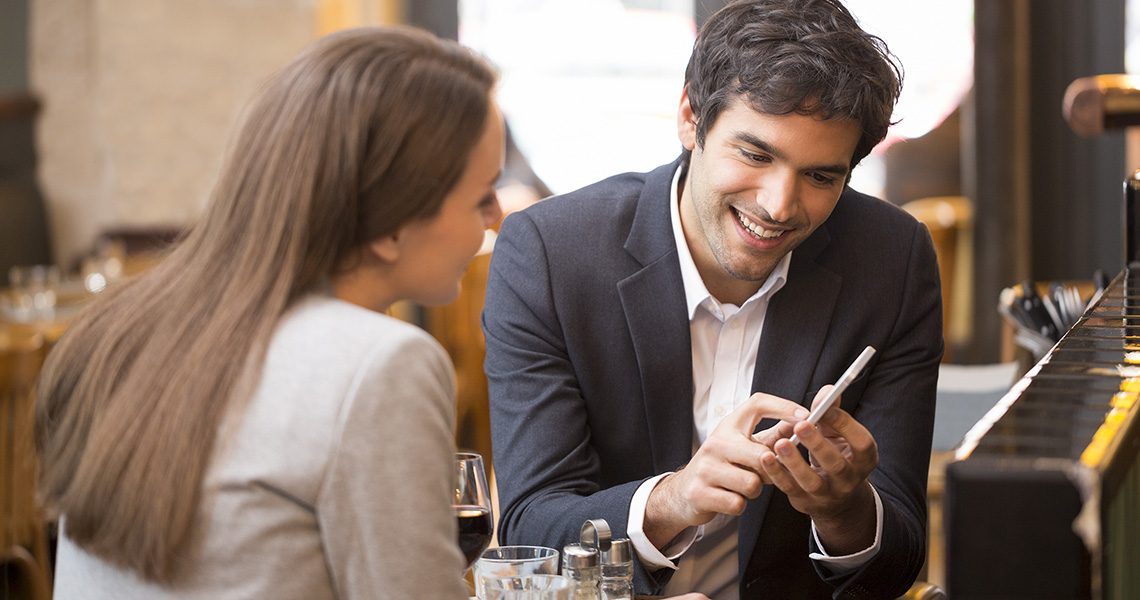 man shares information with a client on his phone