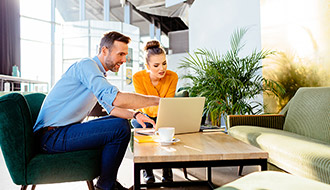 a man and a woman discussing what's on a laptop